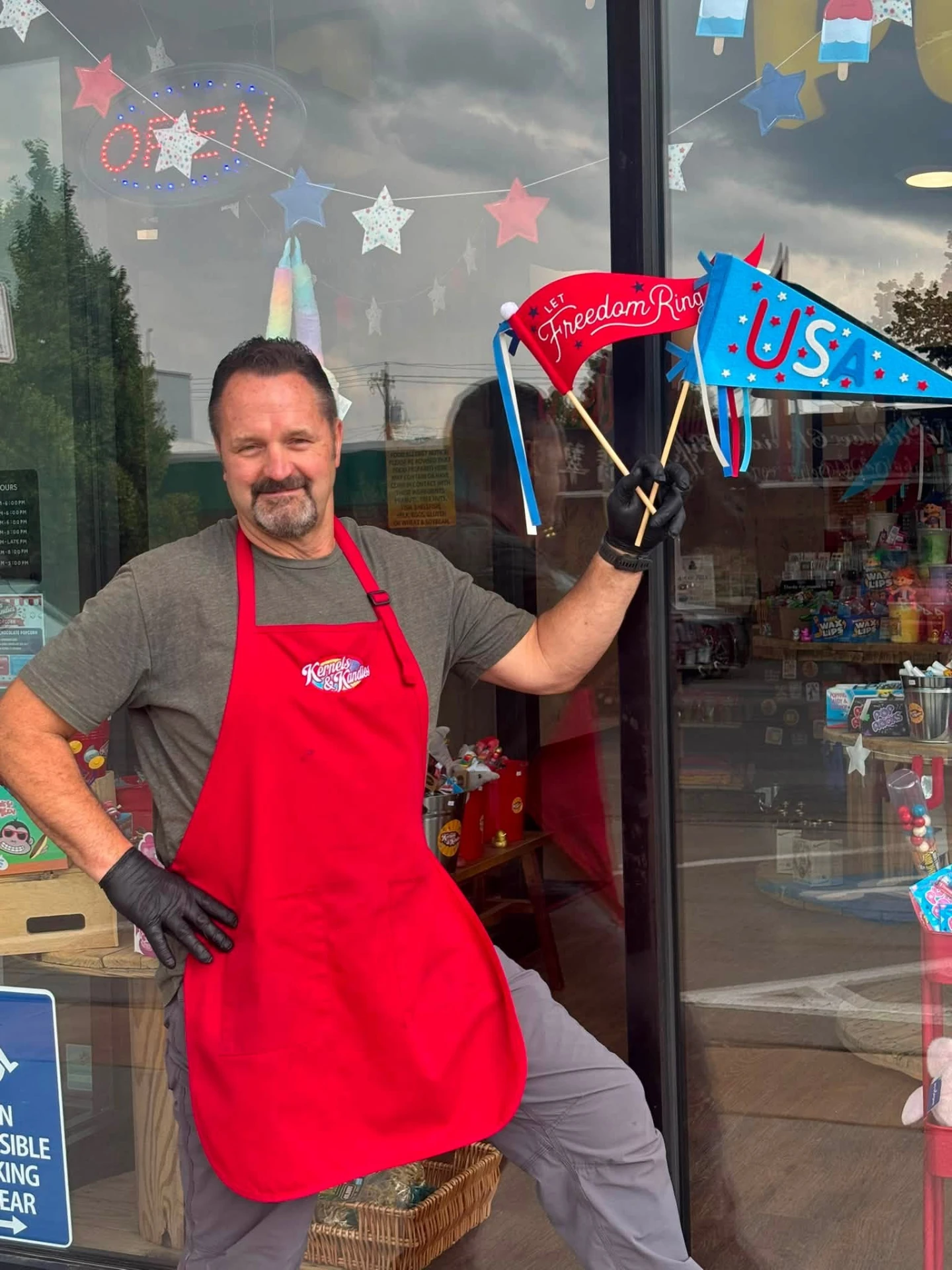 Owner outside the Spearfish storefront with holiday flags